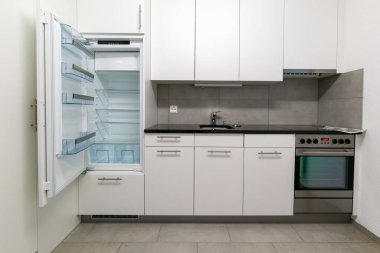 Gri beyaz ve siyah taştan yapılmış basit ve modern bir mutfak manzarası.