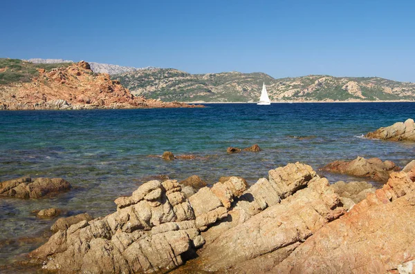 Sardunya granit sahil boyunca beyaz yelkenli — Stok fotoğraf