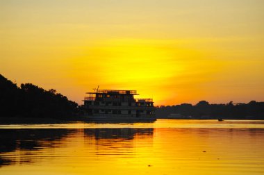 Cruise boat on the Amazon river at sunset. clipart