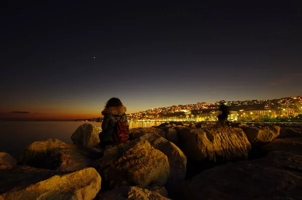 Joven turista sentada en las rocas del puerto de Nápoles . — Foto de Stock