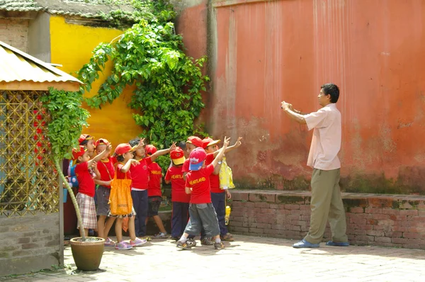 Öğretmen çocukların sınıfının bir fotoğraf çeker. 