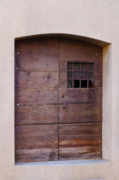 Puerta de madera vieja con ventana pequeña — Foto de Stock