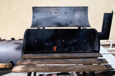 Bahçede klasik Drum Barrel kömür kömürü. Ateşli eski barbekü. Retro Alevli Kömür Ofset Smoker Bbq. Yaz mangalı, barbekü, bbq ve parti kavramı. 
