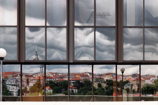 Reflections of Prague buildings and  thunder sky in mirrored windows. Window reflections.