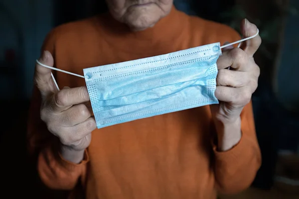 Coronavirüs enfeksiyonunu önlemek için tıbbi maskeli yaşlı bir kadın. Kıdemli kadın yüz maskesi takıyor. Covid-19 karantina