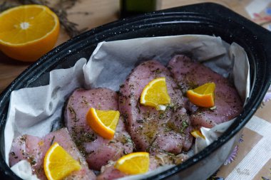 Çiğ tavuk (hindi) fileto ile kaplanmış otlar ve fırın tepsisindeki portakal dilimleri kızartma için hazırlandı. Ev yapımı yemek..