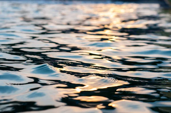 Smooth surface of water at sunset closeup