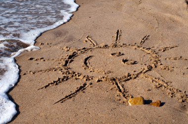 Gülümseyen güneş kum çizilmiş. Yaz dinlenme