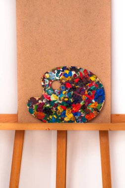 Boş şövale ve renkli yağlı boyalar paleti