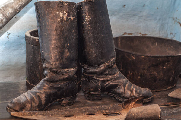 Old worn dusty boots in a rustic interior