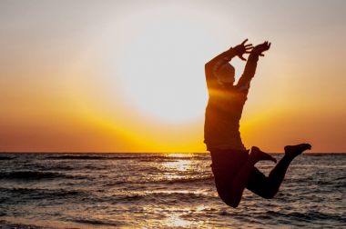 Bir adam sevinçle denizle atlar