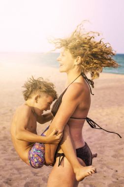 Plajda eğlence olan bir çocuğun annesiyle