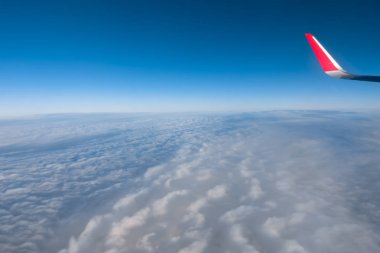 Bulutlar ve gökyüzü bir uçağın penceresinden görüldüğü gibi