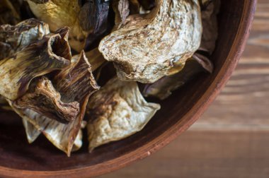 Dilimlenmiş kurutulmuş mantarlar kil tabakta yatıyor. Yakın plan, üst manzara.