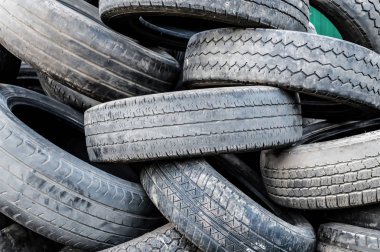 Bir sürü eski, kirli, yıpranmış araba lastiği. Yakın plan.