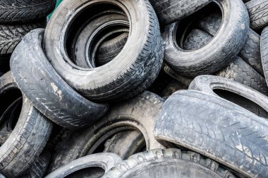 Bir sürü eski, kirli, yıpranmış araba lastiği. Yakın plan.