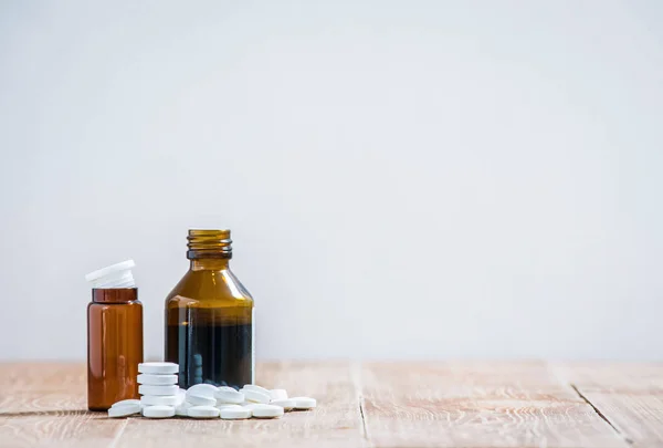 小药瓶和许多白色的药片放在木制桌子上 复制空间 — 图库照片