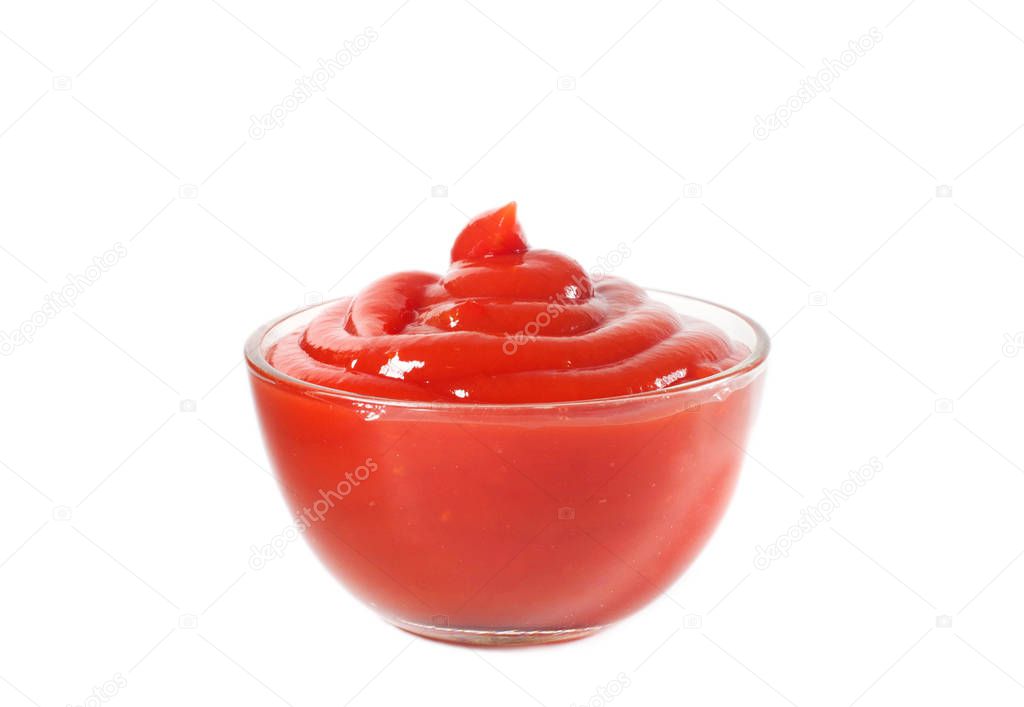 Tomato ketchup in a glass bowl close-up on a white background