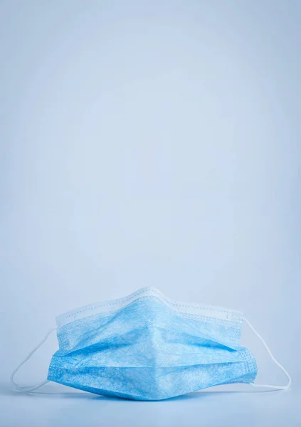 Mavi arka planda mavi koruyucu tıbbi maske. Yakın plan, kopyalama alanı
