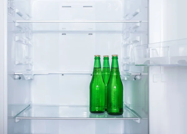 Три Пітні Пляшки Пива Полиці Порожньому Холодильнику Копіювати Простір — стокове фото