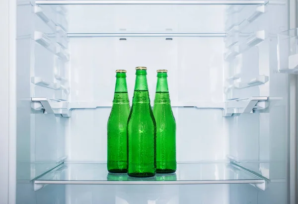 Três Garrafas Cerveja Suadas Estão Uma Prateleira Refrigerador Vazio — Fotografia de Stock