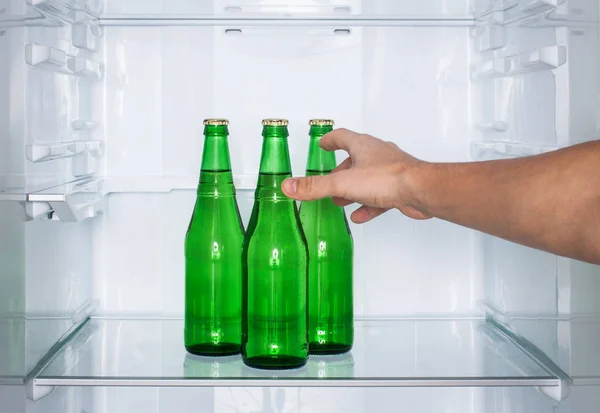 男の手は冷蔵庫でビールのボトルのために達する — ストック写真