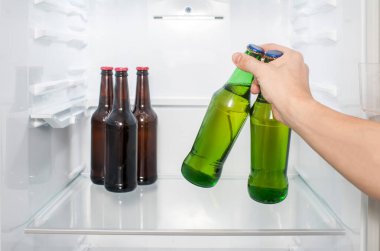 Bir adamın eli buzdolabından iki şişe bira çıkarır. yakın plan
