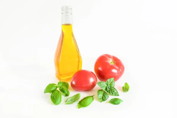 Olive oil, basil leaves and red tomato. Isolated on white background
