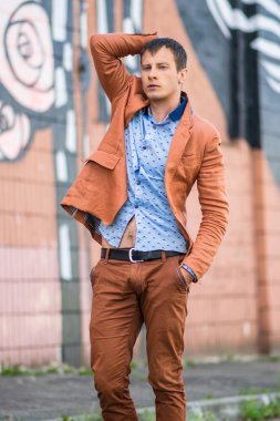 Ayakta ve uzağa bakarak mavi tişörtlü adam Cool moda.