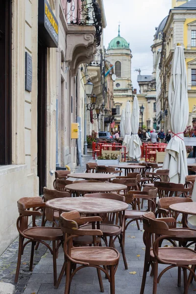 Mesas vacías de café al aire libre en el centro de la ciudad de Lviv — Foto de Stock