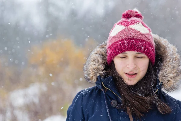 Kız güzel kar yağışı sırasında karlı ormandaki