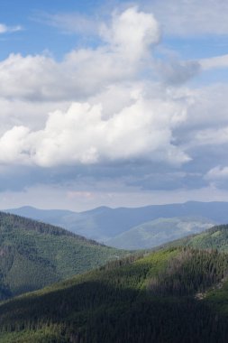 Yeşil dağ tepeleri ve mavi bulutlu gökyüzü