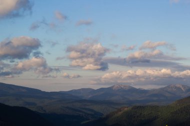 Yeşil dağ tepeleri ve mavi bulutlu gökyüzü manzara