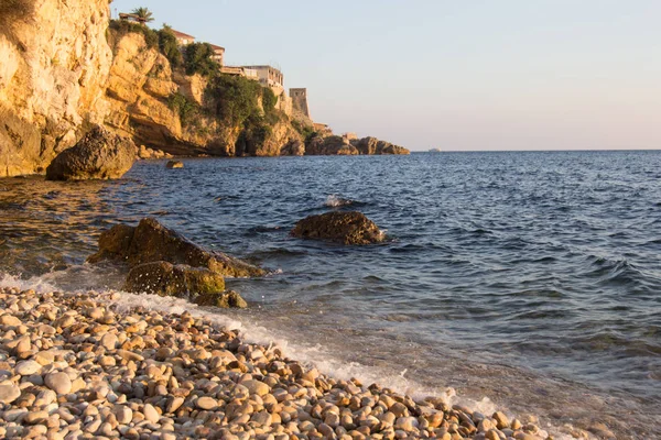 Sunset on the rocky sea beach — Stock Photo, Image