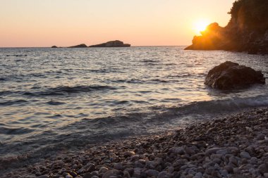 Kayalık deniz sahilde günbatımı