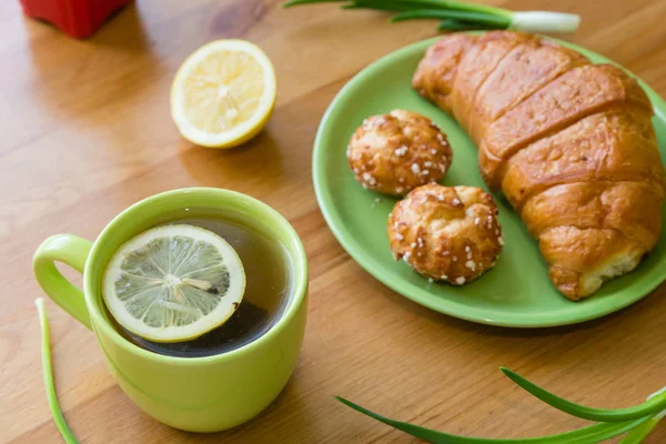 Tee mit Zitrone und Croissant für ein frisches Frühlingsfrühstück — Stockfoto