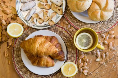 Siyah çay limon sarı kupa kruvasan, çörekler ve ev yapımı kurabiye