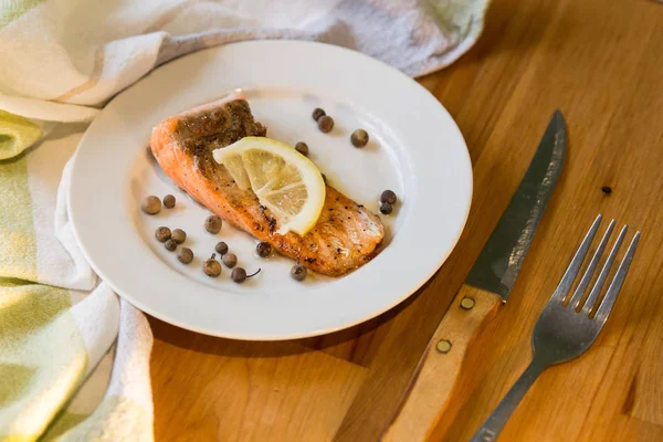 Limon dilimi beyaz plaka üzerinde pişmiş somon fileto bölümünü