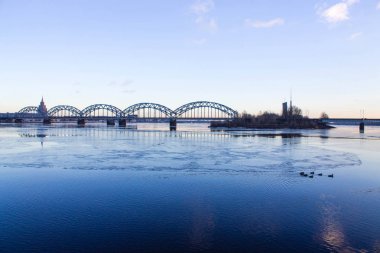 Günbatımı ışık köprüsü ve Riga Nehri üzerinde