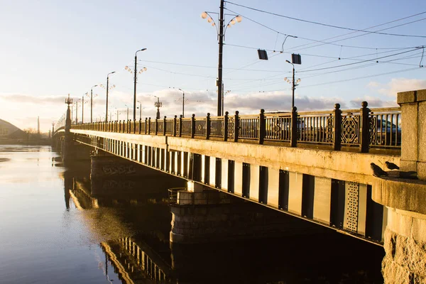 Sunset light over bridge and river in Riga