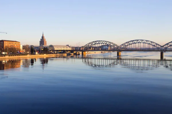 Zonsondergang licht over de brug en de rivier in Riga — Stockfoto