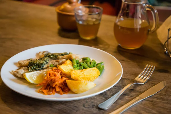 Balık ve cips plaka sebze ve bir plaka üzerinde limon ile