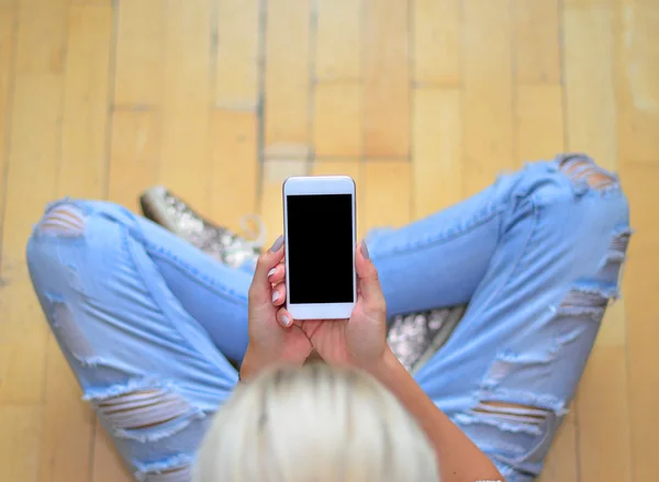 Katta oturan smartphone ile kız