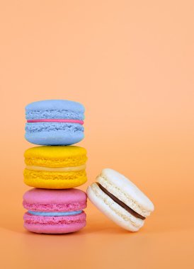 Turuncu arka plan üzerinde renkli macaroons