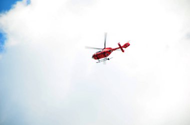 Mavi gökyüzünde kırmızı helikopter 