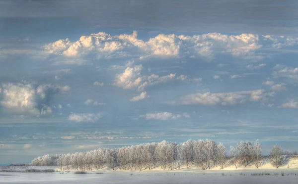 Vinterlandskap med vackra moln Stockfoto