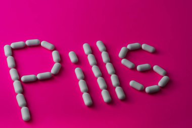 Mor arka planda beyaz haplar.