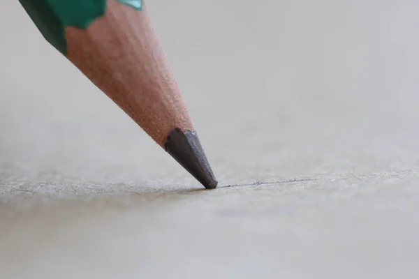 Punto de pluma de grafito en un primer plano extremo de la hoja de papel — Foto de Stock