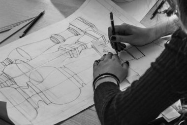 Kız mimar bir plan, tasarım, geometrik şekiller kalem tarafından büyük Ofis Masası, kağıt üzerine çizer.