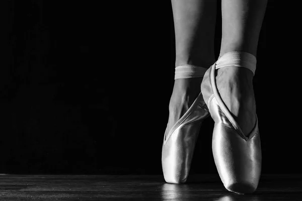 Primer plano clásico de las piernas de la bailarina en pointes en el suelo negro —  Fotos de Stock